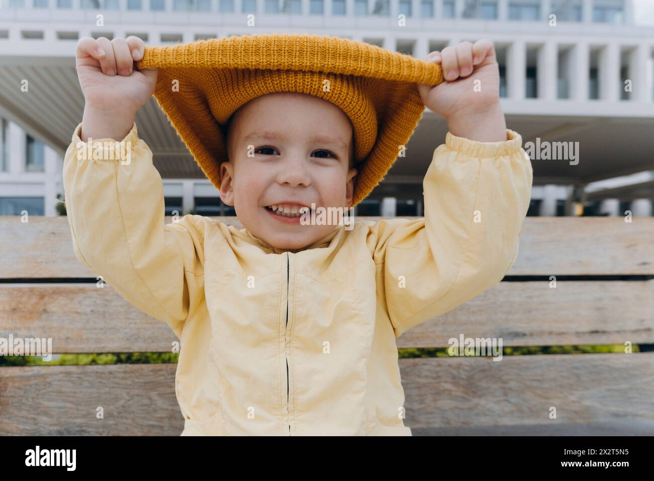 Smiling boy pulling orange knit hat Stock Photo