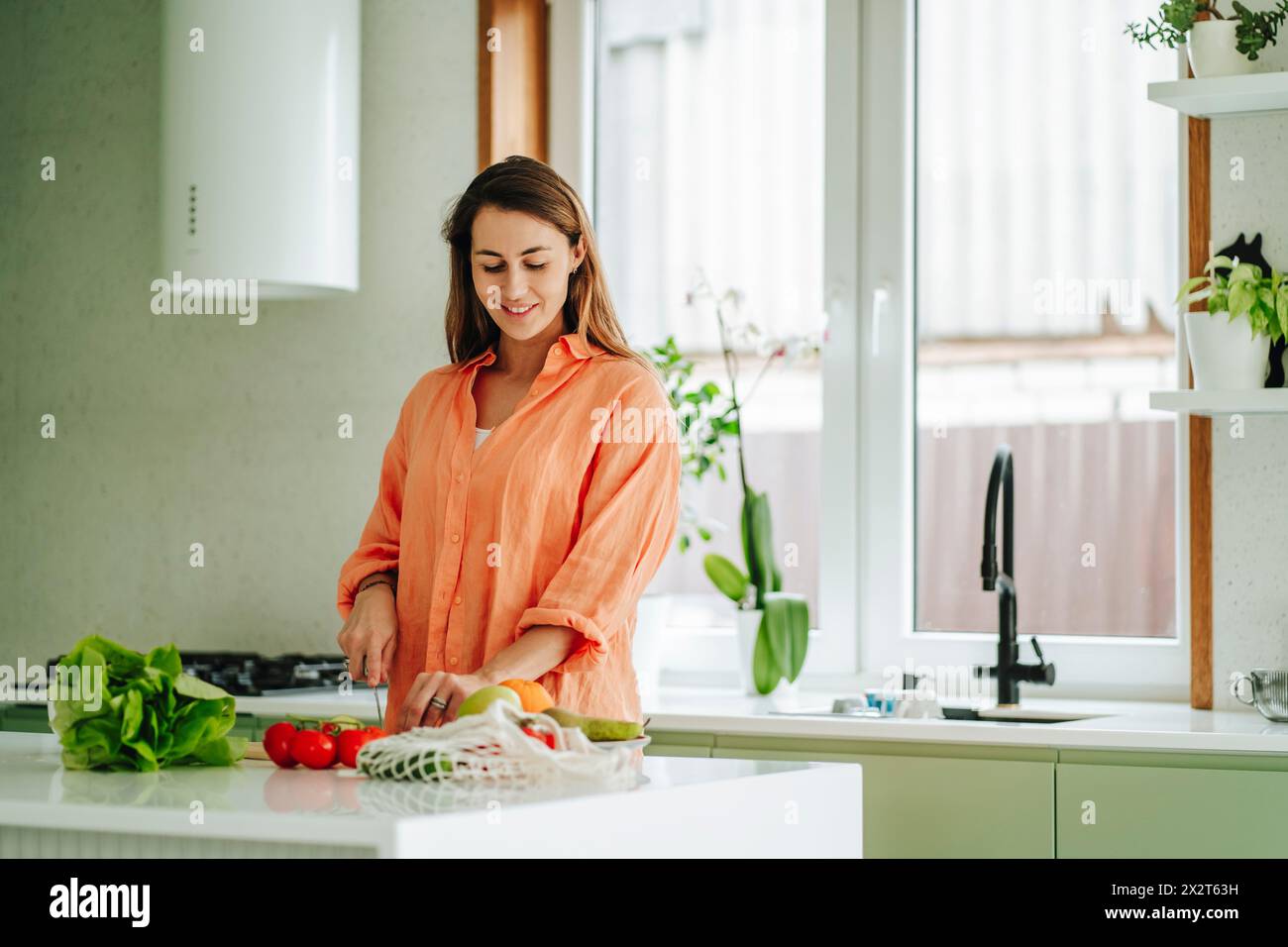 Woman chopping fruit on kitchen island at home Stock Photo Alamy