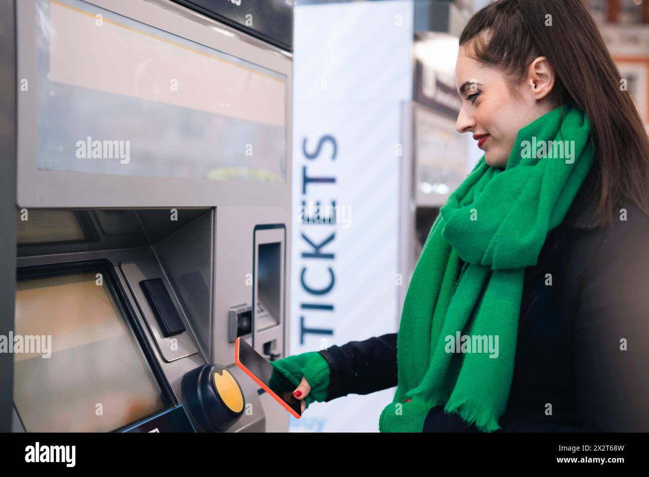 Smiling woman buying ticket through smart phone at train station Stock ...