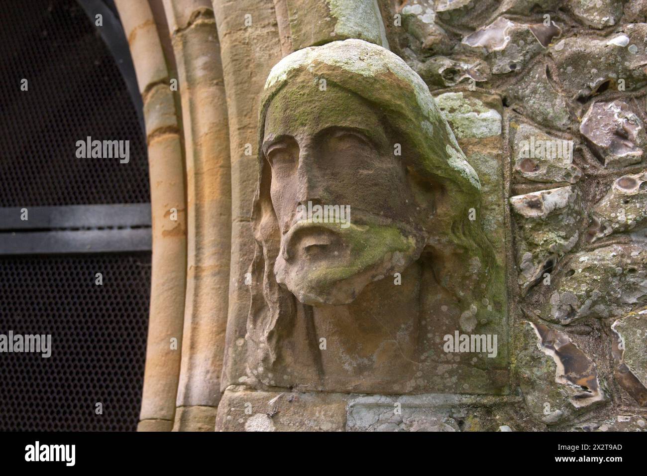 St Bartholamews church stone carving of Jesus on right side of entrance, Albourne, nr Henfield, West Sussex Stock Photo