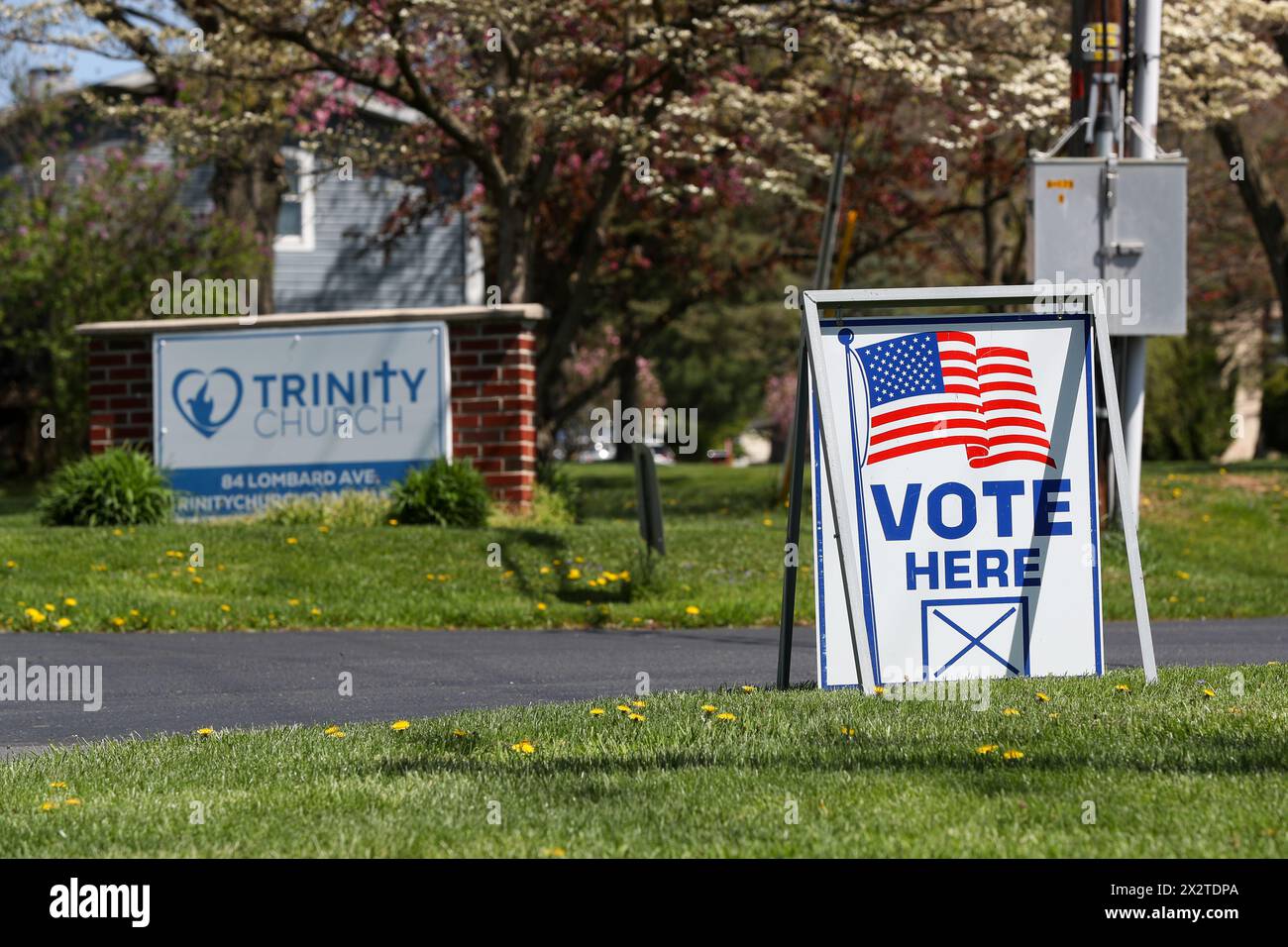 Danville, United States. 23rd Apr, 2024. A 'vote here' sign is seen outside of Trinity Church which serves as a polling station for Mahoning Township in Montour County. Pennsylvania's primary election is held on Tuesday, April 23, 2024. Credit: SOPA Images Limited/Alamy Live News Stock Photo