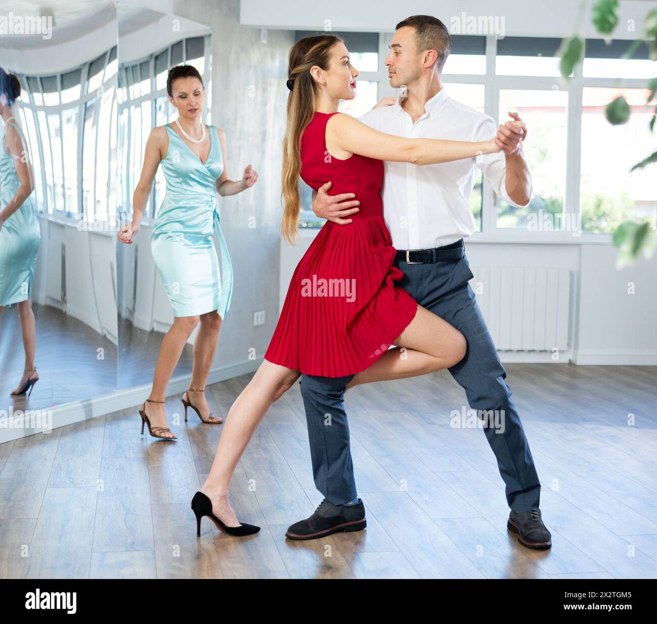 Elegant couple performing expressive tango in dance studio Stock Photo ...