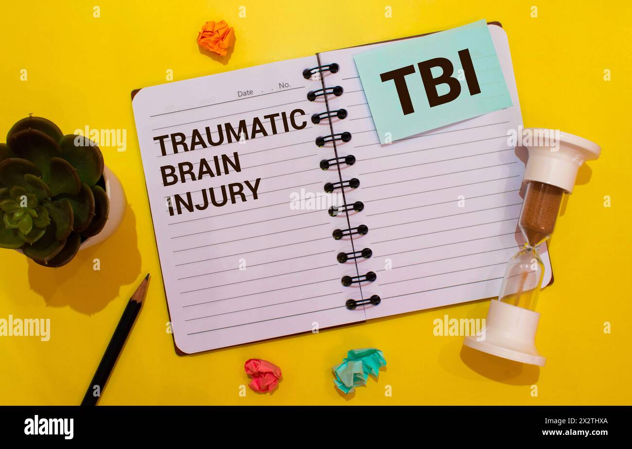 TBI traumatic brain injury symbol. Concept words TBI traumatic brain injury on white note on a beautiful background from dollar bills. Pen. Medical an Stock Photo