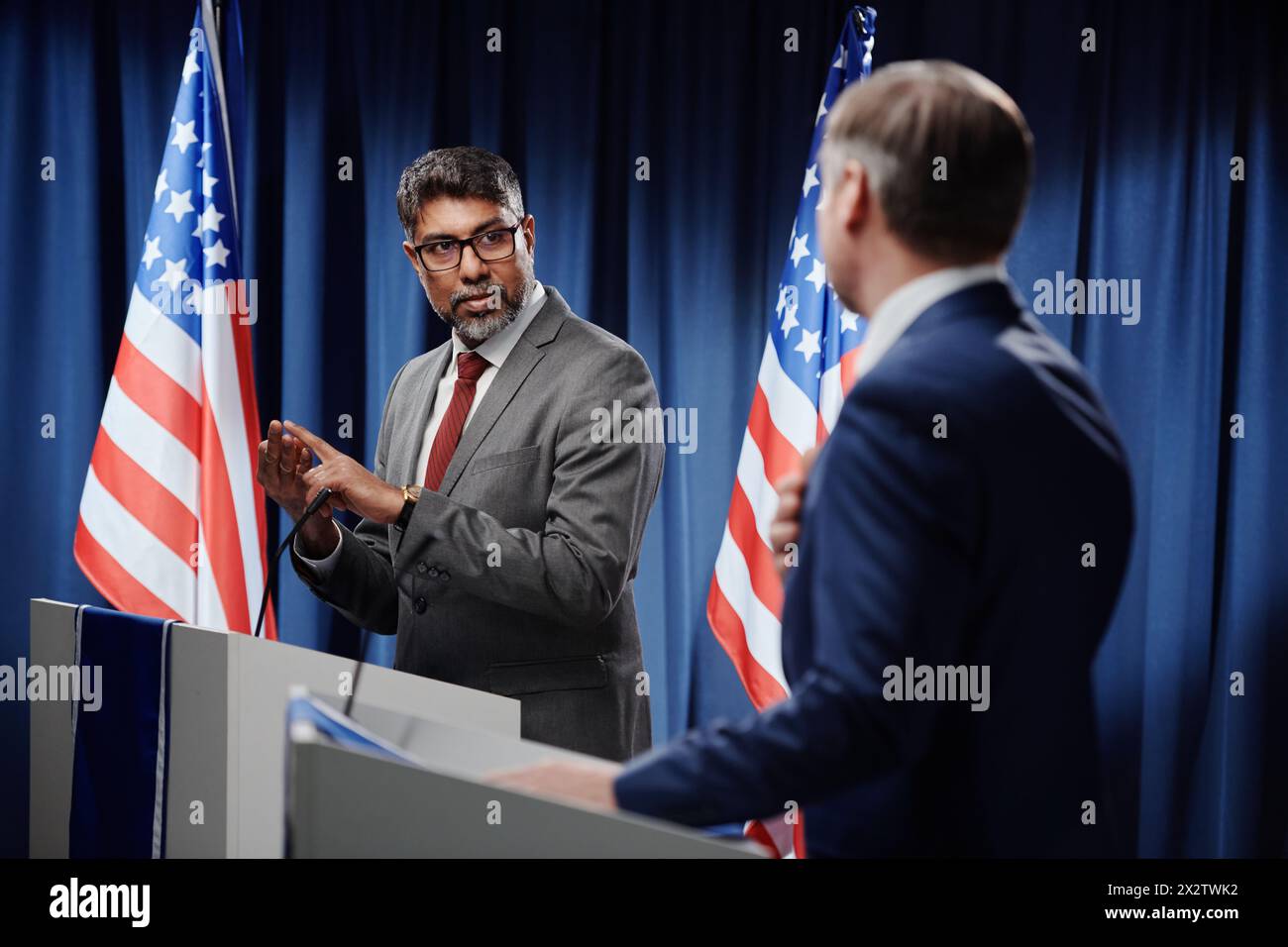 Confident mature multiethnic male political leader enumerating new points in developing economics and foreign policy at press conference Stock Photo