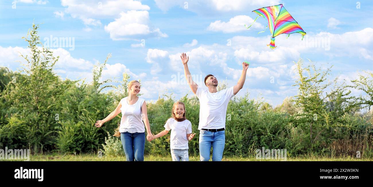 Happy family flying kite outdoors Stock Photo