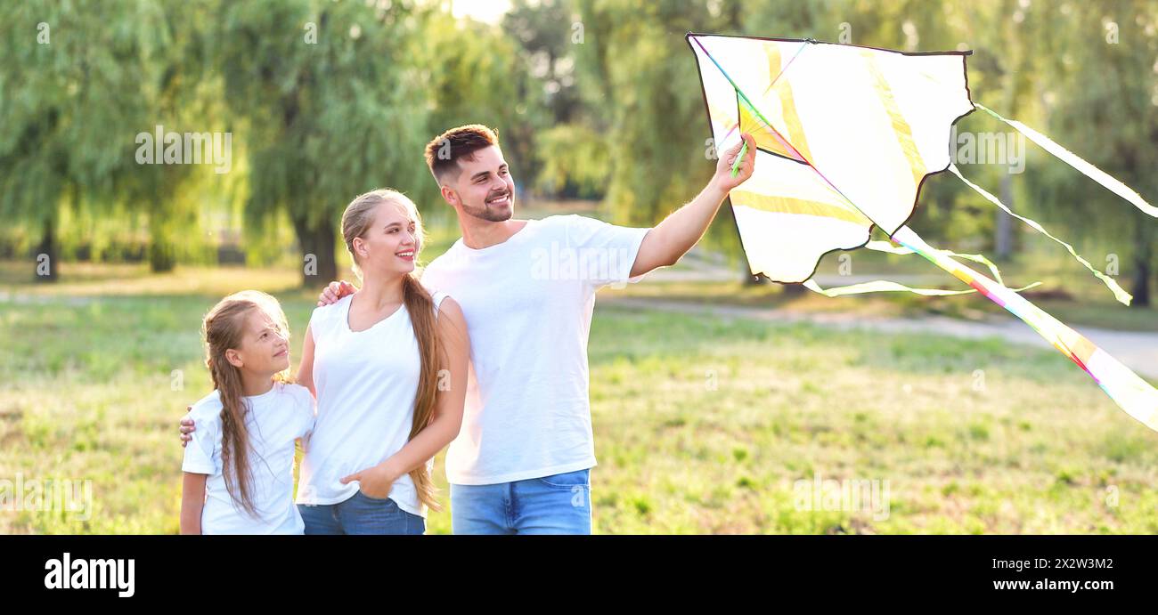 Happy family flying kite in park Stock Photo