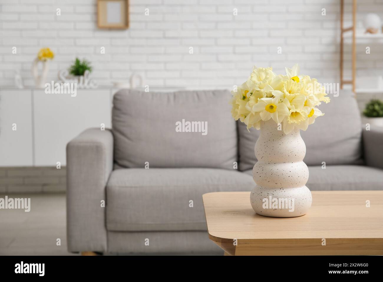 Interior of living room with beautiful narcissus on table Stock Photo