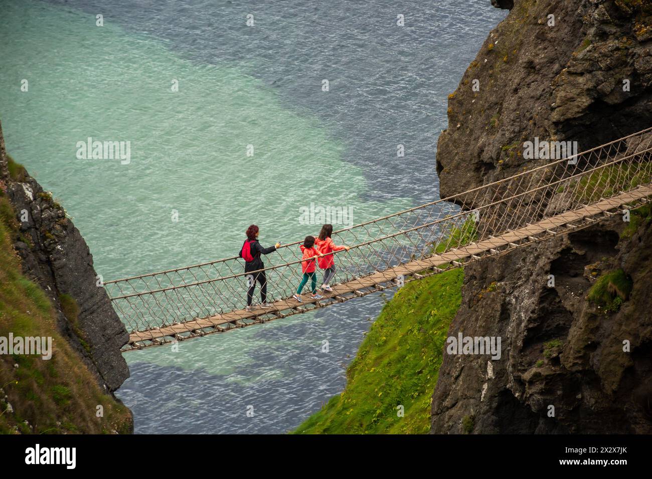 17.07.2019, Ballycastle, Northern Ireland, United Kingdom - Carrick-a-Rede harbour bridge, a link between Carrick Island (R) and the mainland (Atlanti Stock Photo
