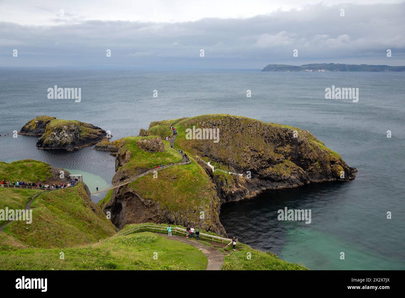 17.07.2019, Ballycastle, Northern Ireland, United Kingdom - Carrick-a-Rede Harbour Bridge, a link between Carrick Island (R) and the mainland (Atlanti Stock Photo