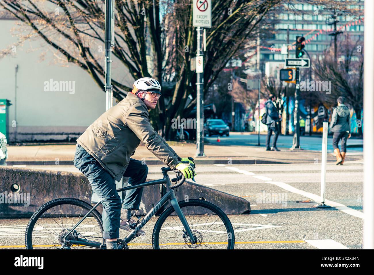 A man riding a road bike in the bike lane stopped at a traffic light at the intersection of Dunsmuir and Citadel Parade streets. Stock Photo