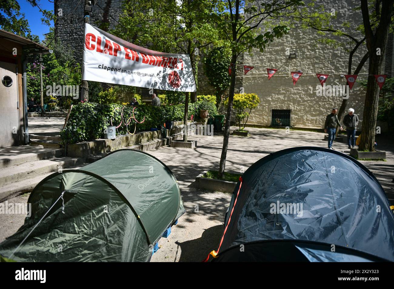 Players compete in petanque (boules game) beneath a placard reading “the Clap is in danger” at the Lepic Abbesses Petanque Club (Clap) in Paris, France on April 23, 2024. Petanque is a game similar to bowls that is as dear to the French as village cricket is to the English. During the Belle epoque, Montmartre was the artistic heart of Paris, home to Pablo Picasso, Claude Monet and Pierre-Auguste Renoir, who were attracted by its cheap rents and bohemian nightlife. Today the picturesque district that was one of the settings of the 2001 film Amelie is a magnet for tourists. Property prices have Stock Photo