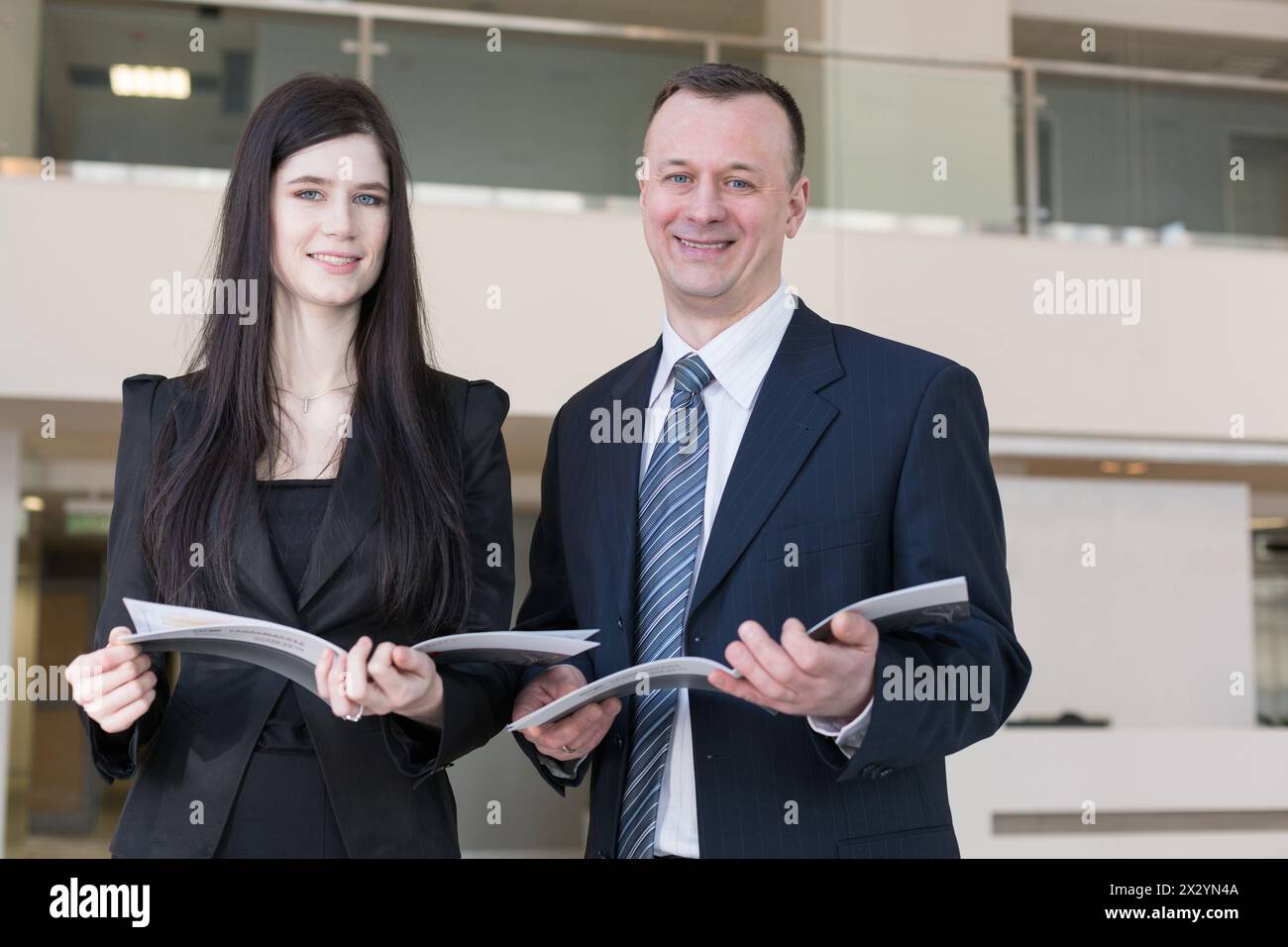Business man and woman are holding magazines Stock Photo