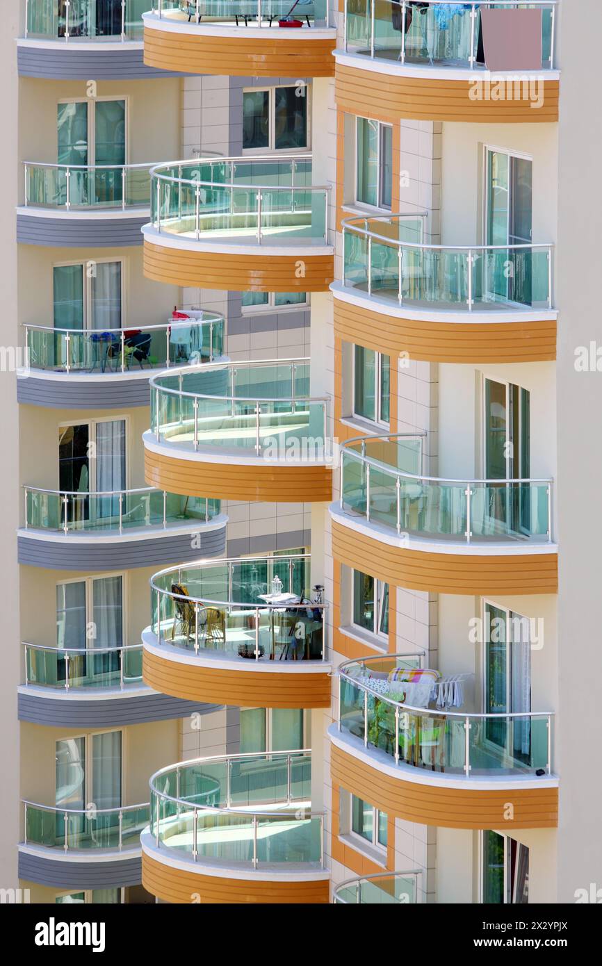 Balconies of tall buildings with glass railings, chairs and tables ...