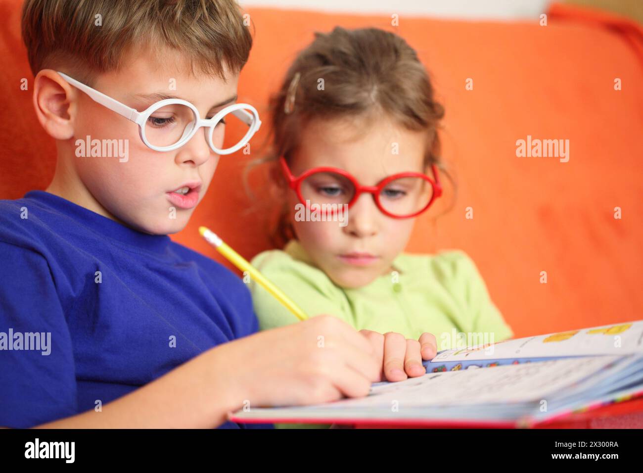 Girl and boy intently doing homework, focus on the hinge glasses Stock ...