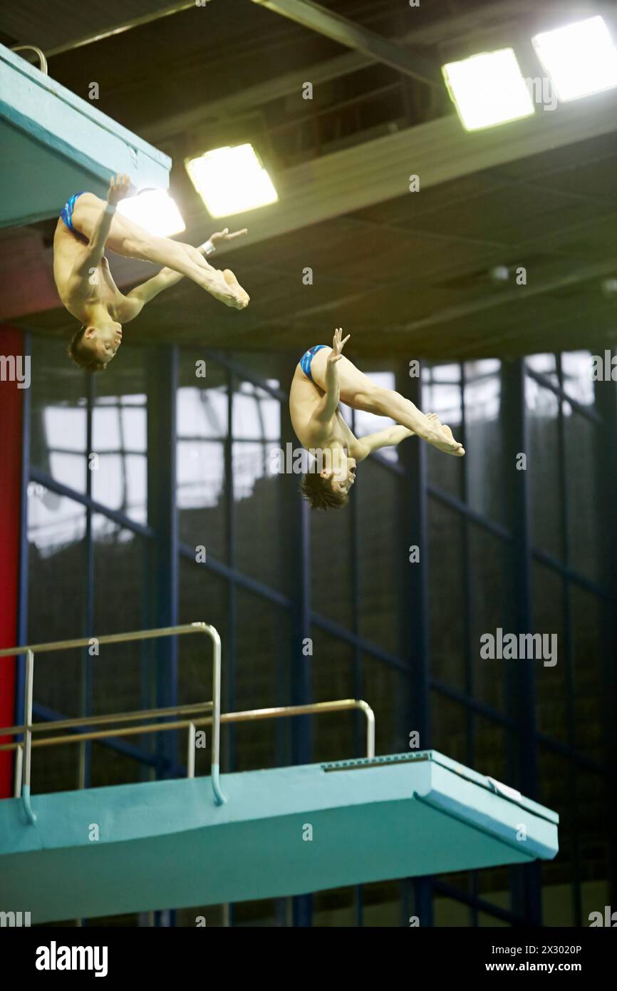 MOSCOW - APR 13:  Athletes jump from tower at competitions on syncronized springboard diving in Pool of SC Olympic on day of third phase of World Seri Stock Photo