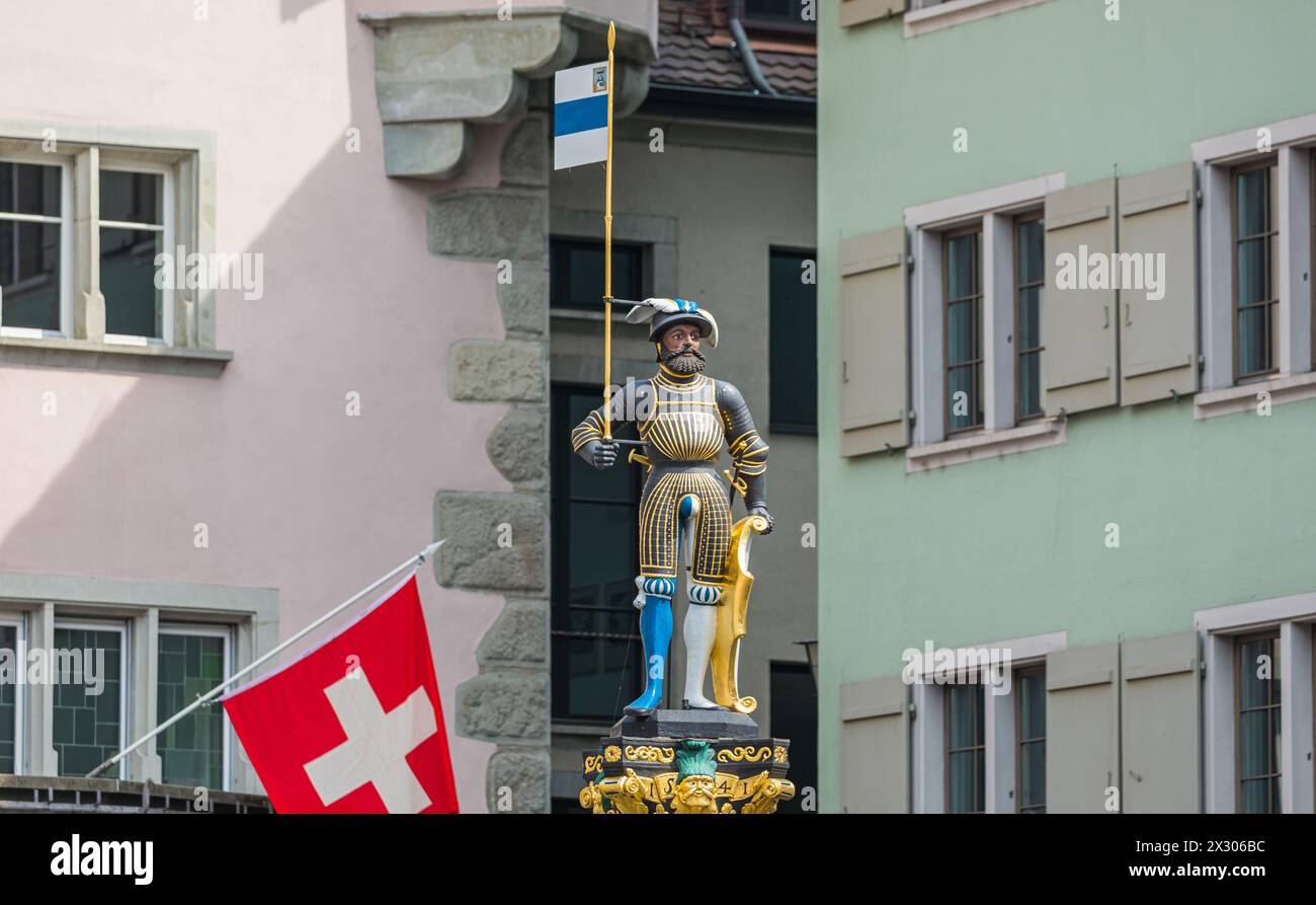 Die Statue auf dem Kolinbrunnen in der Stadt Zug gibt Spielraum für viele historische Intepretationen. Er trägt das Wappen und die Flagge des Schweize Stock Photo
