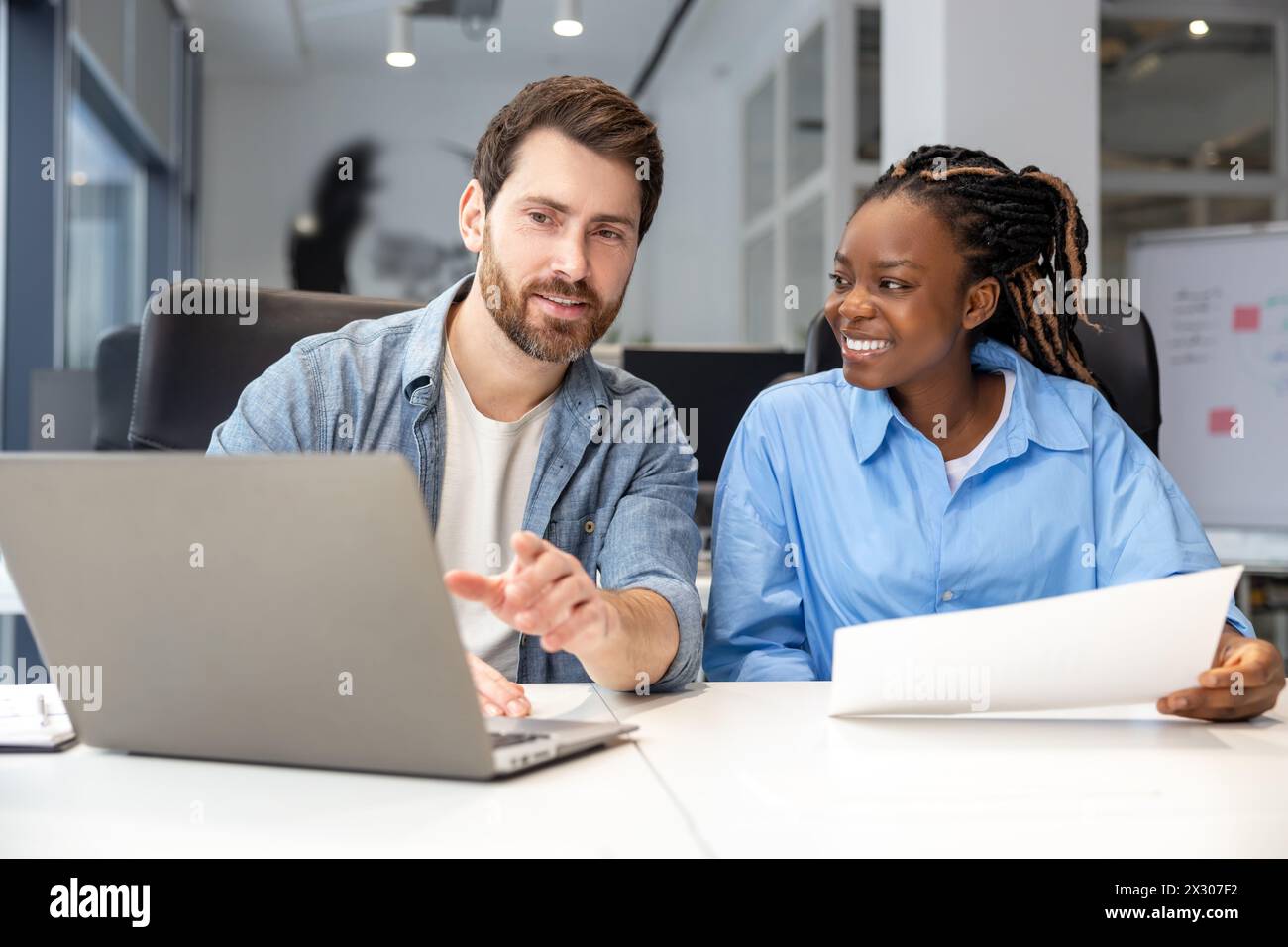 Multicultural colleagues using laptop for creating new business project ...