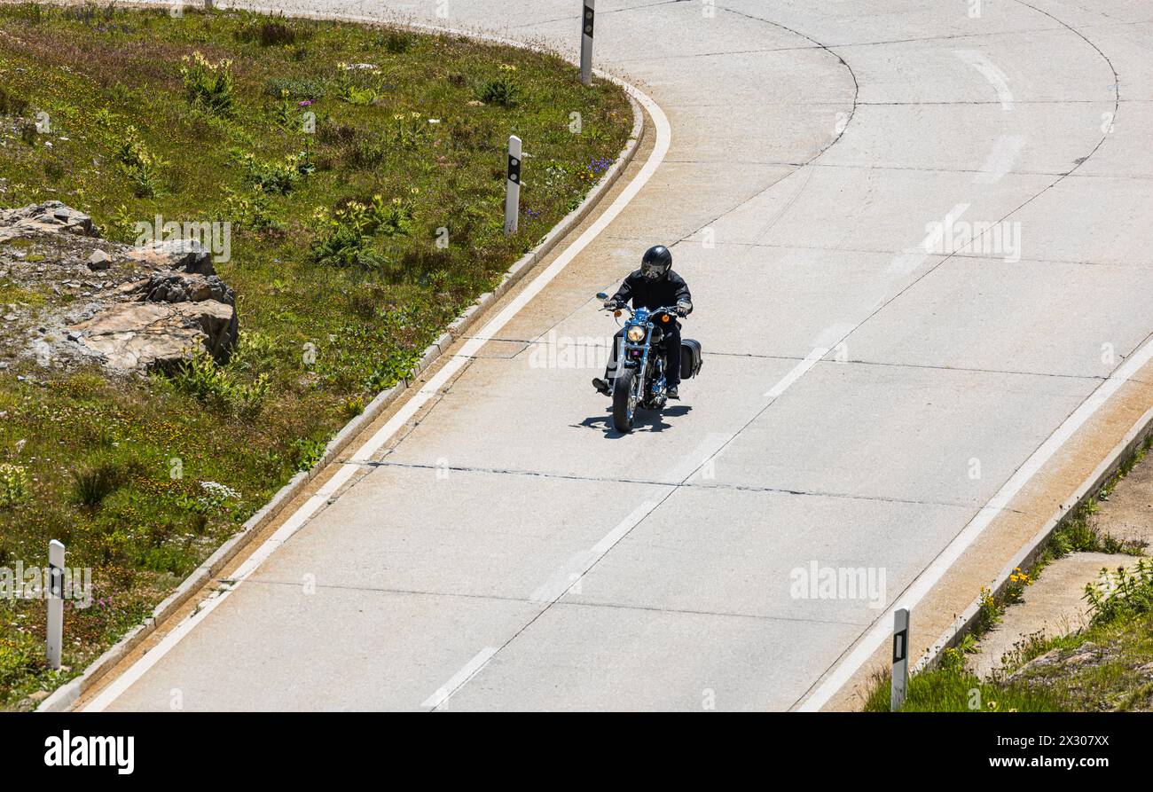 Ein Motorradfahrer fährt die Passstrasse auf den Nufenenpass hoch. (Nufenenpass, Schweiz, 18.07.2022) Stock Photo