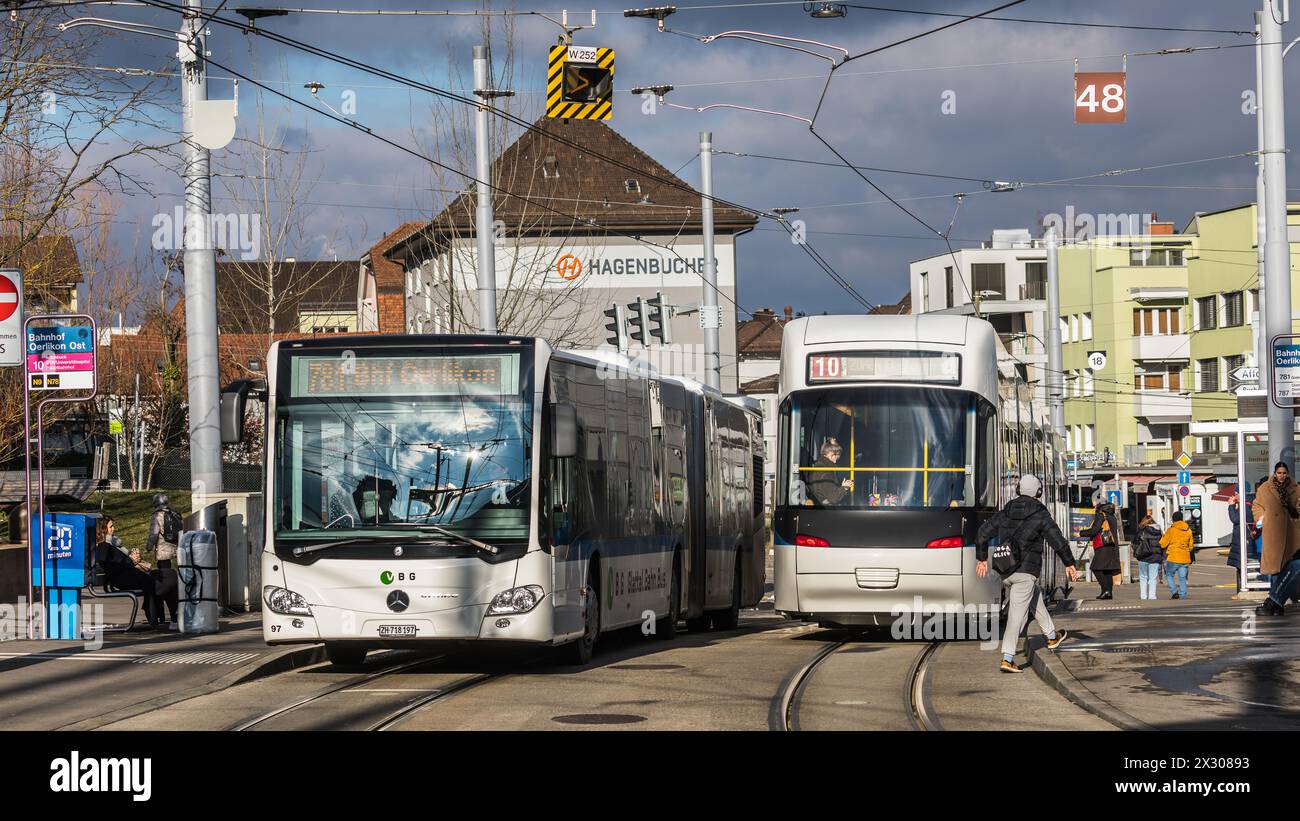 Zürich, Schweiz - 11. Januar 2021: Ein Cobra-Tram der Tramlinie 10 Richtung Flughafen und ein Bus in Richtung Bahnhof Oerlikon steht an der Haltestell Stock Photo