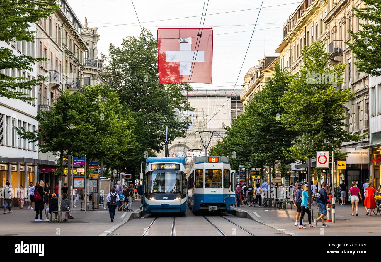 Die Passagiere steigen an der Zürcher Bahnhofstrasse in die beiden VBZ-Trams der Linie 13 mit Ziel Albisgüetli und in die Linie 6 mit Ziel Zoo Zürich Stock Photo