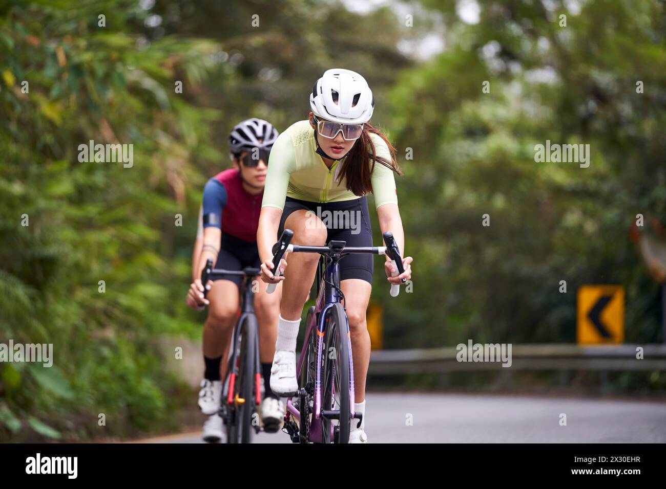 group of young asian professional cyclists riding bike training on rural road Stock Photo
