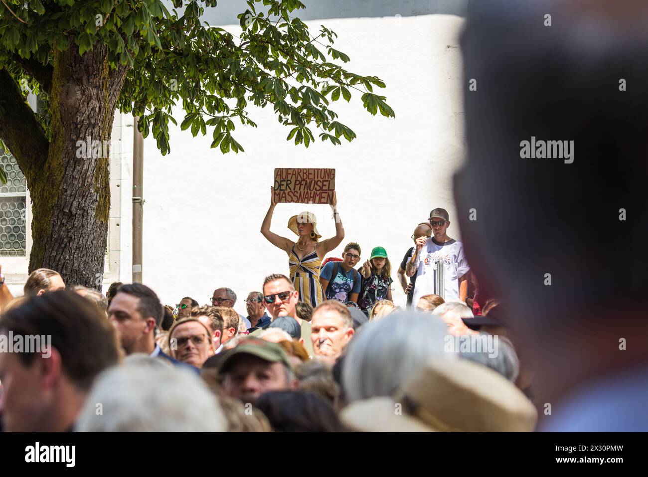 Bundesrat Guy Parmelin sieht eine Frau die ein Schild in die Höhe hält. Auf diesem wird gefordert, dass die Coronavirus Pandemie aufgearbeitet werden Stock Photo