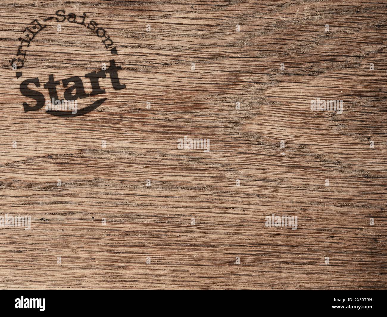 Stamp with text grill saison start on texture of an old used oak plank wood using as header Stock Photo