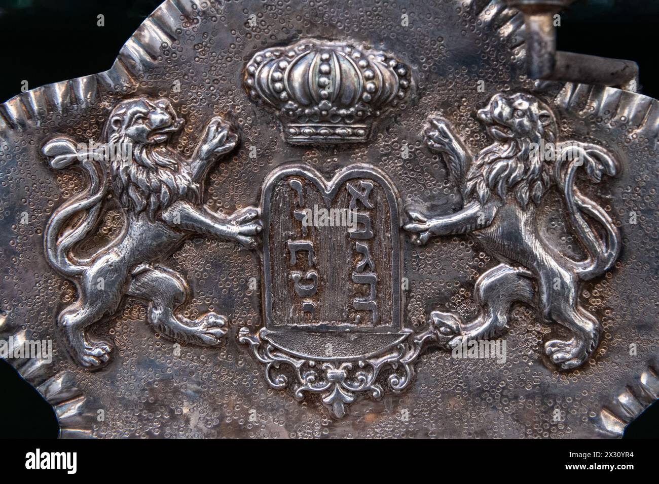 Antique metal plate engraved with two lions holding up the tablets of the 10 commandments, with 10 Hebrew letters representing the numbers one through Stock Photo