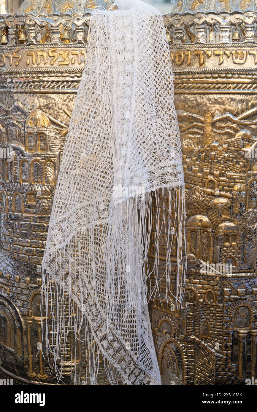 A white scarf with tassels draped over a silver case enclosing a Sefardi style Torah scroll during prayers at the Western Wall in Jerusalem, Israel. Stock Photo