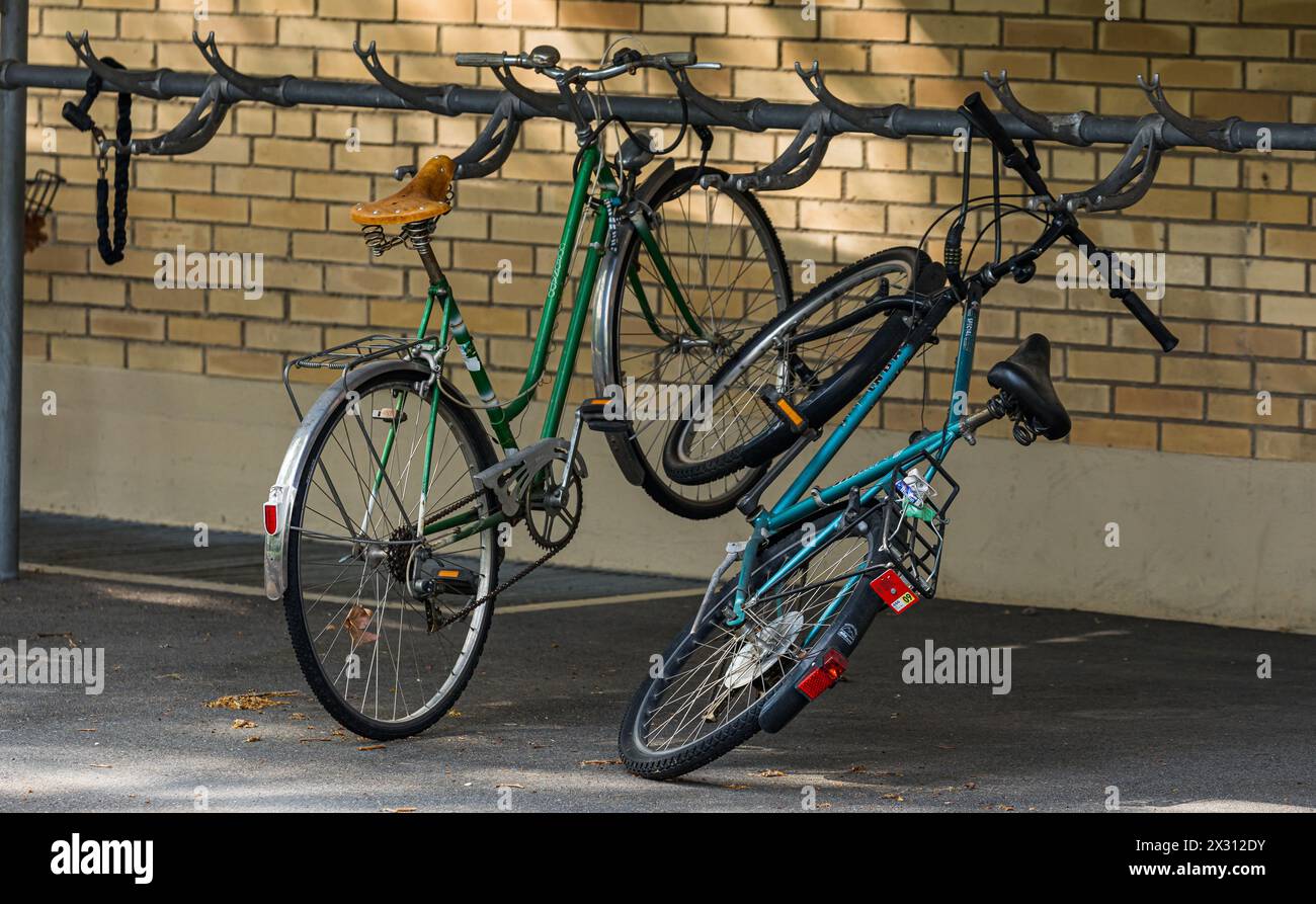 Bei einem Fahrradständer sind zwei eher ältere Fahrräder parkiert. (Zug, Schweiz, 01.05.2022) Stock Photo