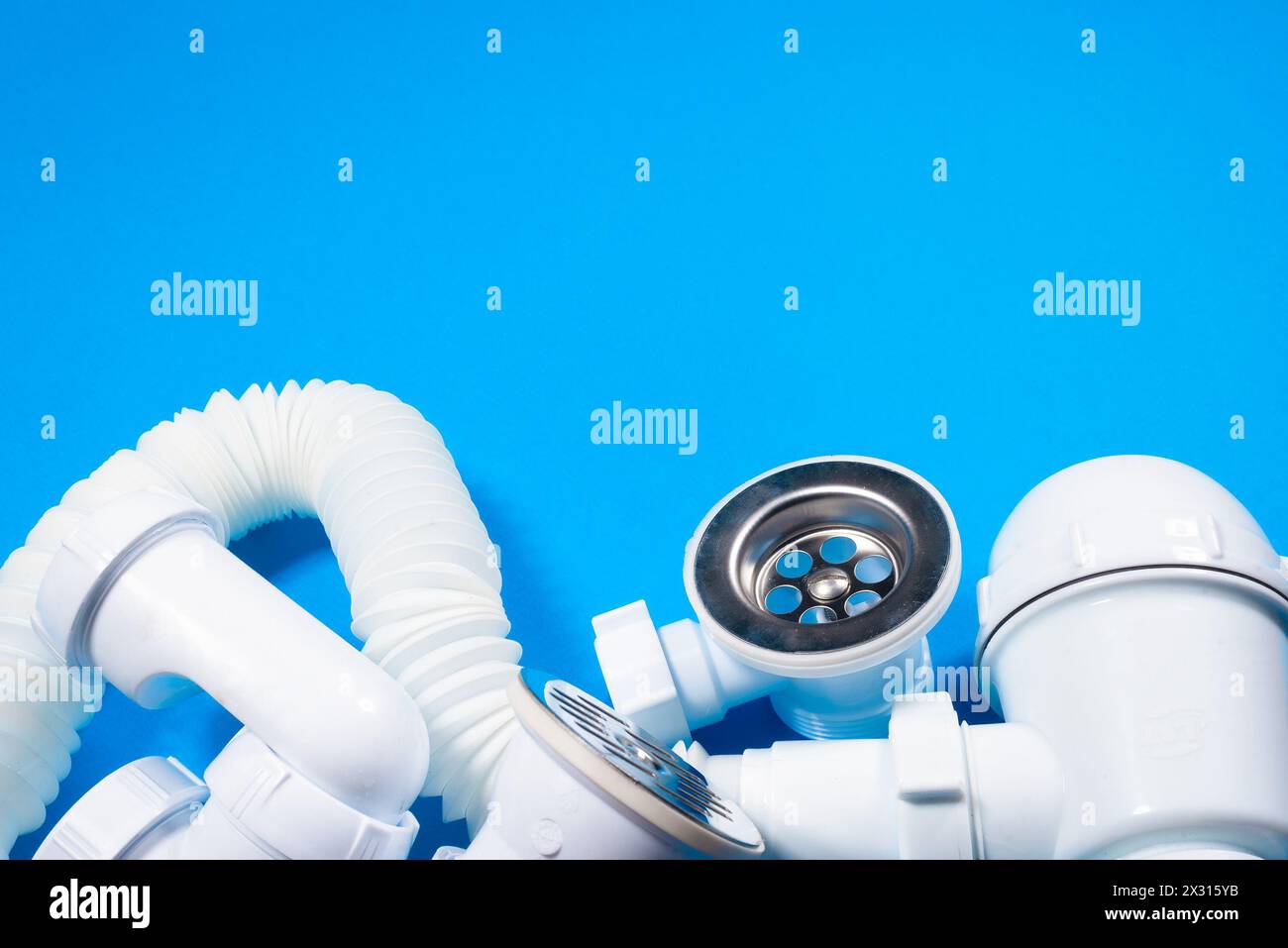 Bathtub drain pipeline system parts on the blue top view background copy space. Siphon flat lay. Stock Photo