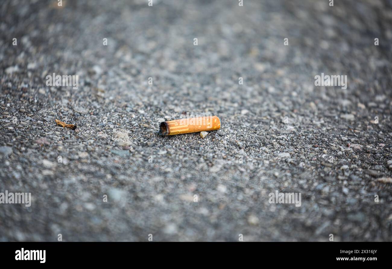Ein achtlos weggerworfener Zigarettenstummel liegt am Boden. (Basel-Kleinhüningen, Schweiz, 13.04.2022) Stock Photo