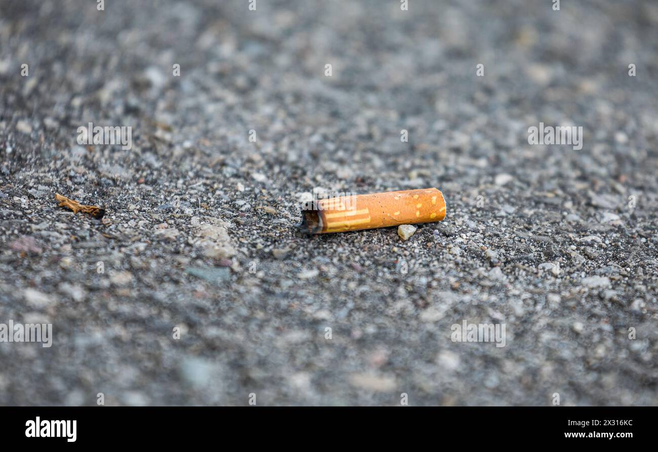 Ein achtlos weggerworfener Zigarettenstummel liegt am Boden. (Basel-Kleinhüningen, Schweiz, 13.04.2022) Stock Photo