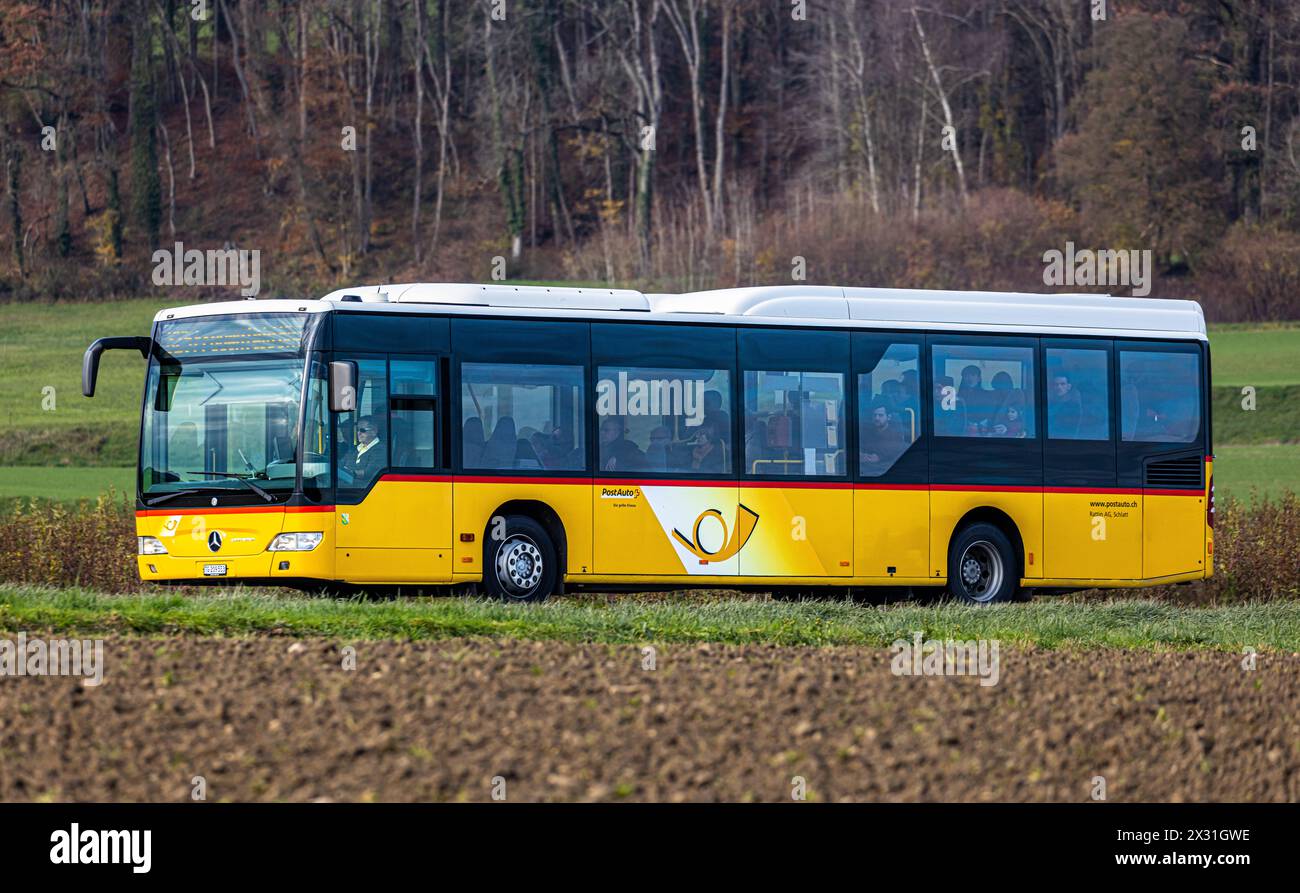 Ein Postauto fährt auf der Frauenfelderstrasse in Herdern im Kanton Thurgau. (Herden, Schweiz, 27.11.2023) Stock Photo