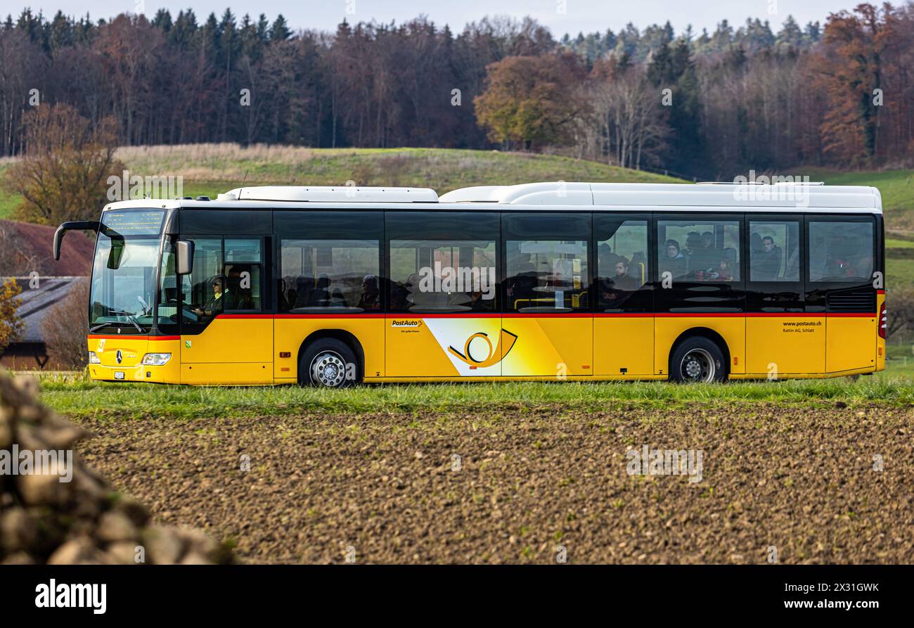 Ein Postauto fährt auf der Frauenfelderstrasse in Herdern im Kanton Thurgau. (Herden, Schweiz, 27.11.2023) Stock Photo