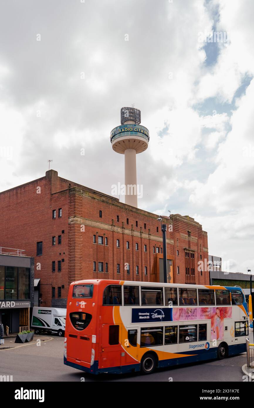 Liverpool, UK, April 11 2024: Radio City tower, seen from the Queens Square, near St. John building. City buses pass through the intersection. Stock Photo