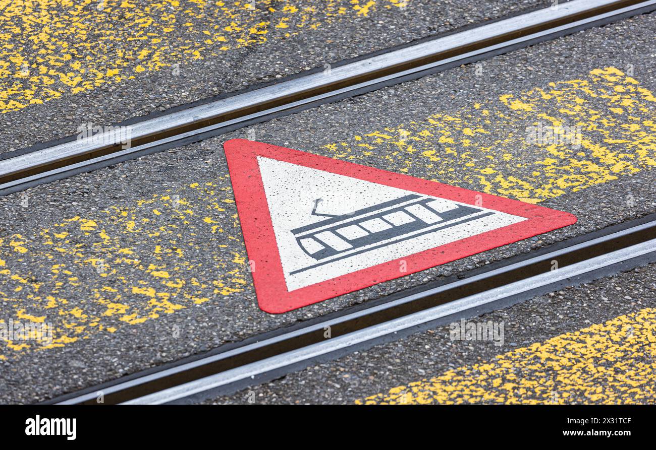 Fussgänger werden mittels Gefahrensymbolen auf dem Boden beim überqueren der Strasse über den Fussgängerstreifen vor der Strassenbahn gewarnt. (Zürich Stock Photo