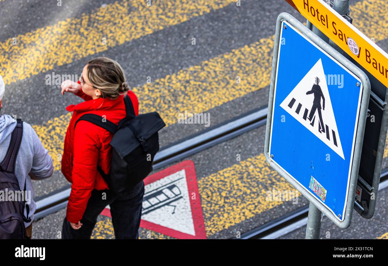 Bei einem Fussgängerstreifen in der Stadt Zürich am Limmatquai sowie dazugehöriges Verkehrsschild. Mittels einem Gefahrensymbol am Boden werden Fussgä Stock Photo