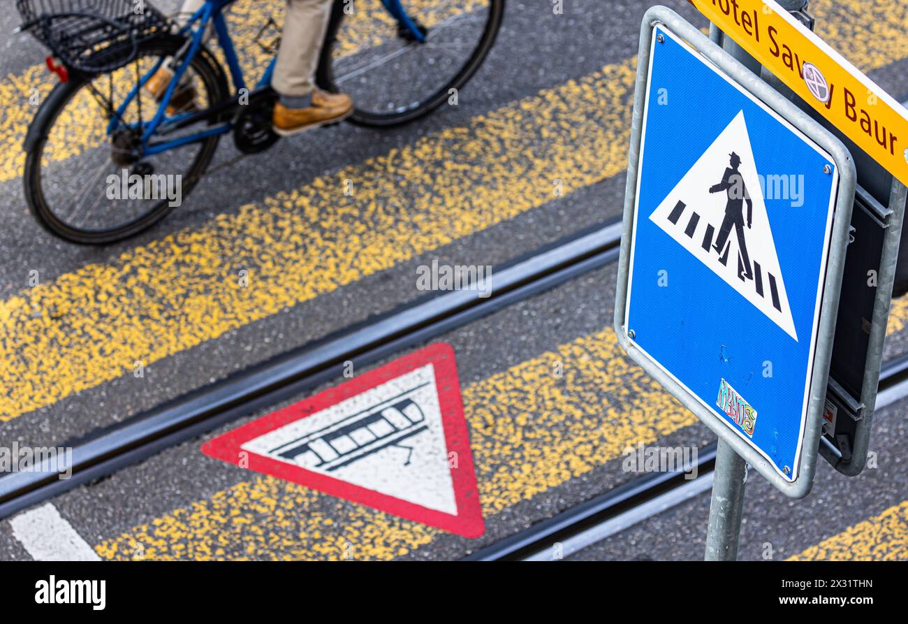 Bei einem Fussgängerstreifen in der Stadt Zürich am Limmatquai sowie dazugehöriges Verkehrsschild. Mittels einem Gefahrensymbol am Boden werden Fussgä Stock Photo