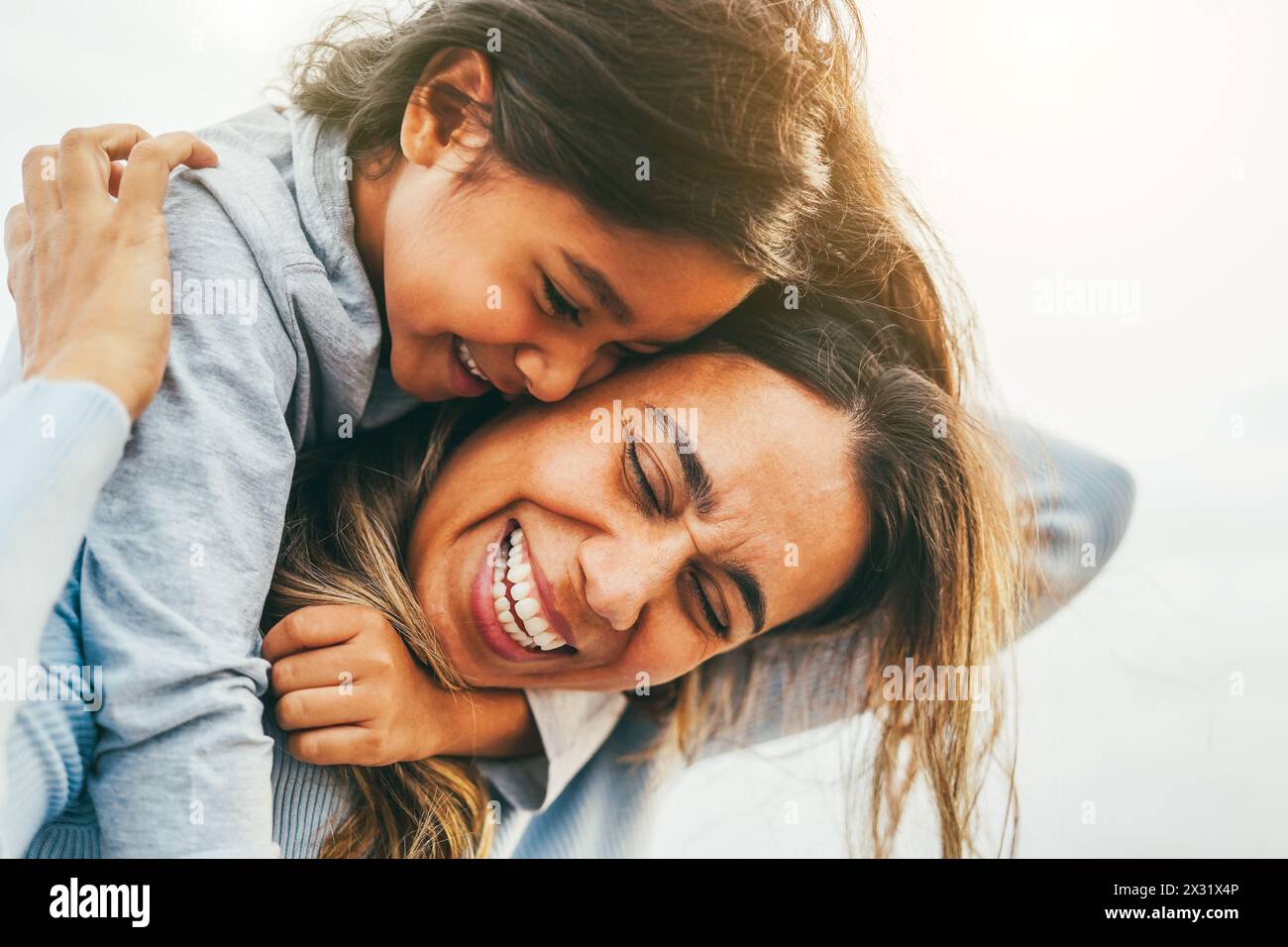 Happy latin mother and daughter having fun outdoor - Love, family and mum day concept - Main focus on woman face Stock Photo