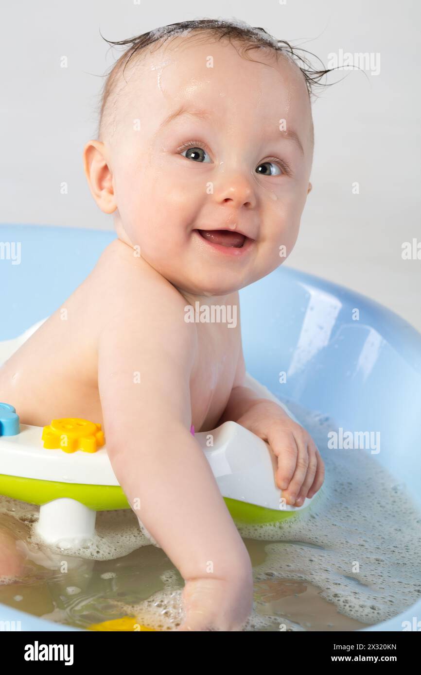 Smiling baby girl in a bathtube with toys Stock Photo