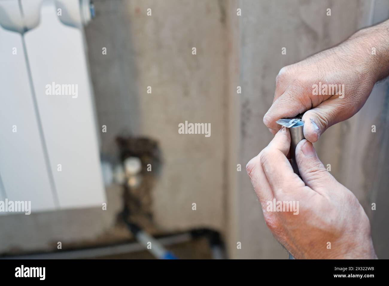 A worker cleans the pipe preparing it for crimping Stock Photo