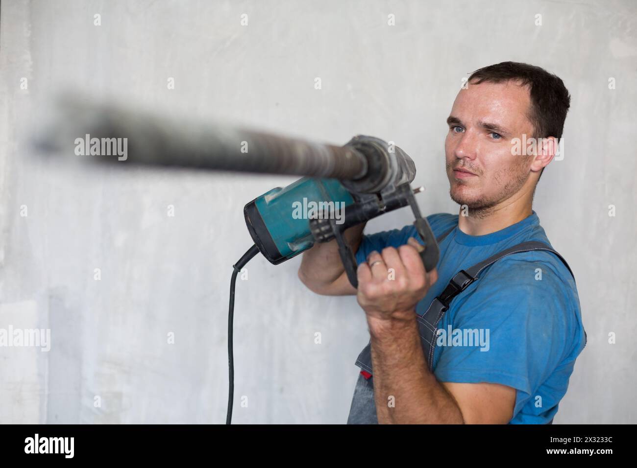 Worker makes a hole using a perforator Stock Photo