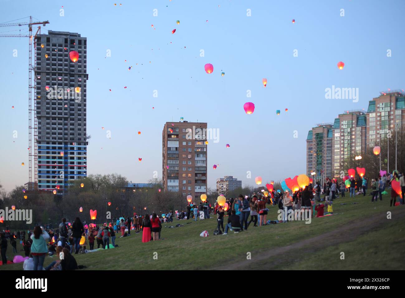 MOSCOW - MAY 2: People are launching a chinese fly lanterns in the sky in a district of Moscow on May 2, 2013 in Moscow, Russia. Stock Photo
