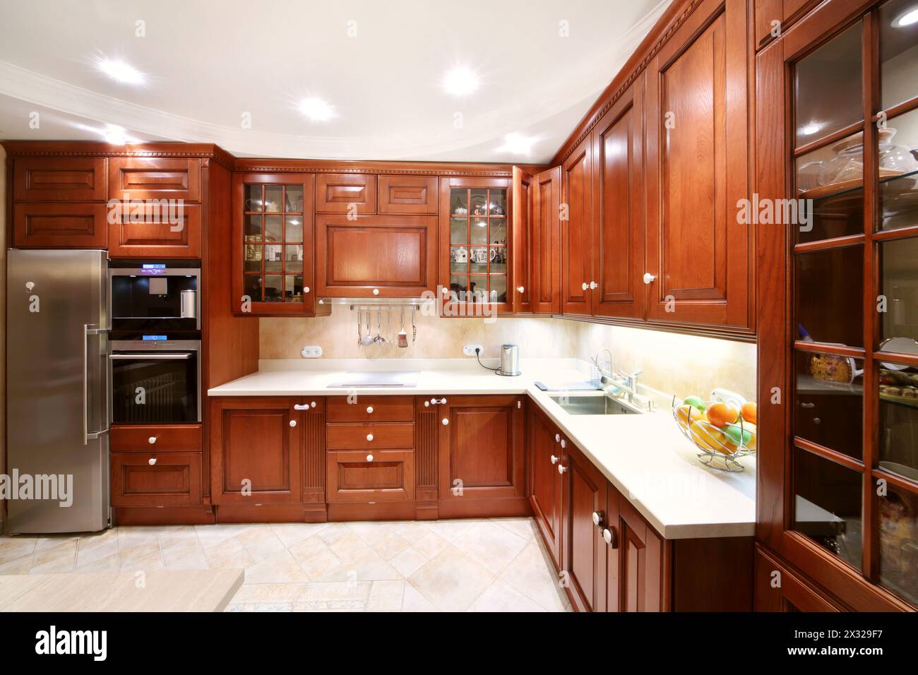 Simple wooden kitchen cupboards, countertops, refrigerator and oven in