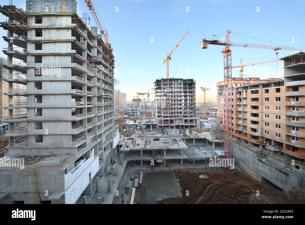 Multi-storey buildings under construction and cranes at sunny day. Stock Photo