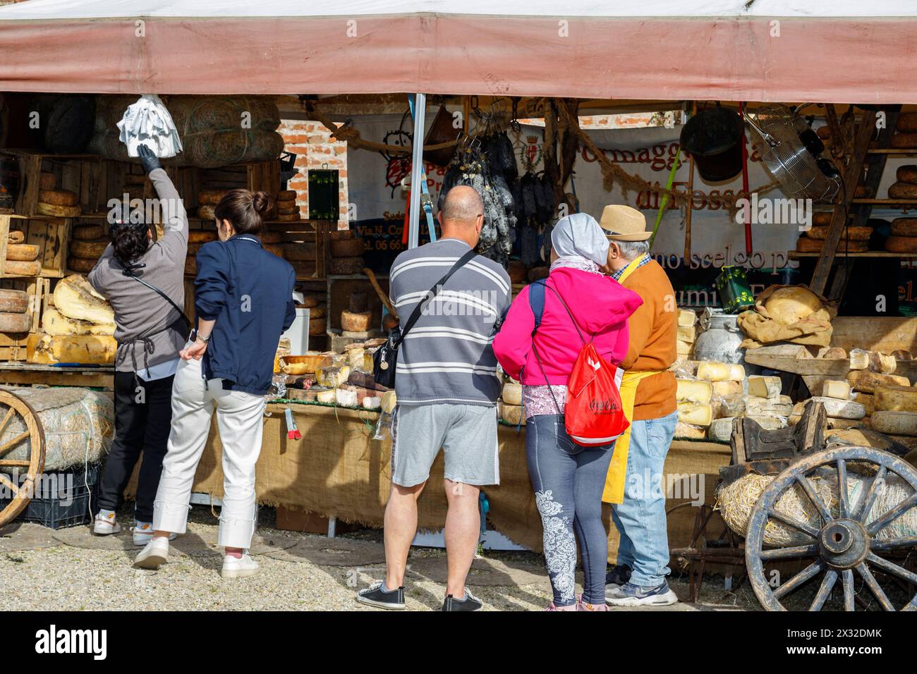 Moncalieri, Piedmont, Italy - April 20, 2024: Customers in front of a market stall selling artisanal cheeses and cured meats. Stock Photo