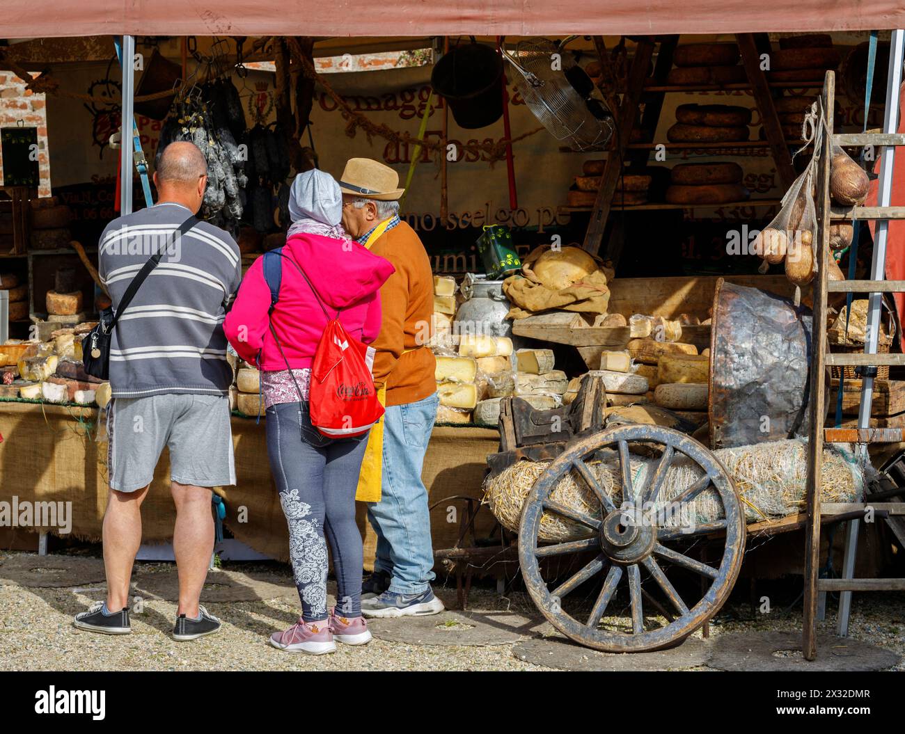 Moncalieri, Piedmont, Italy - April 20, 2024: Customers in front of a market stall selling artisanal cheeses and cured meats. Stock Photo