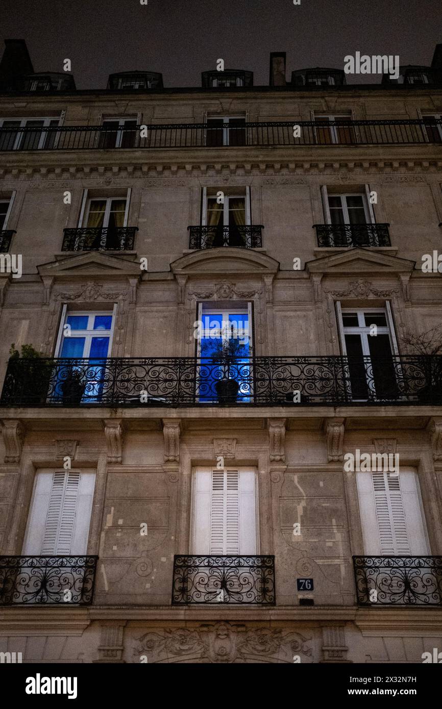 A Haussmann-style apartment building at dusk in the midst of the ...