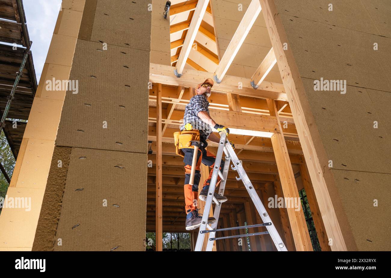 Professional Construction Contractor Worker Reaching Ceiling Beams From